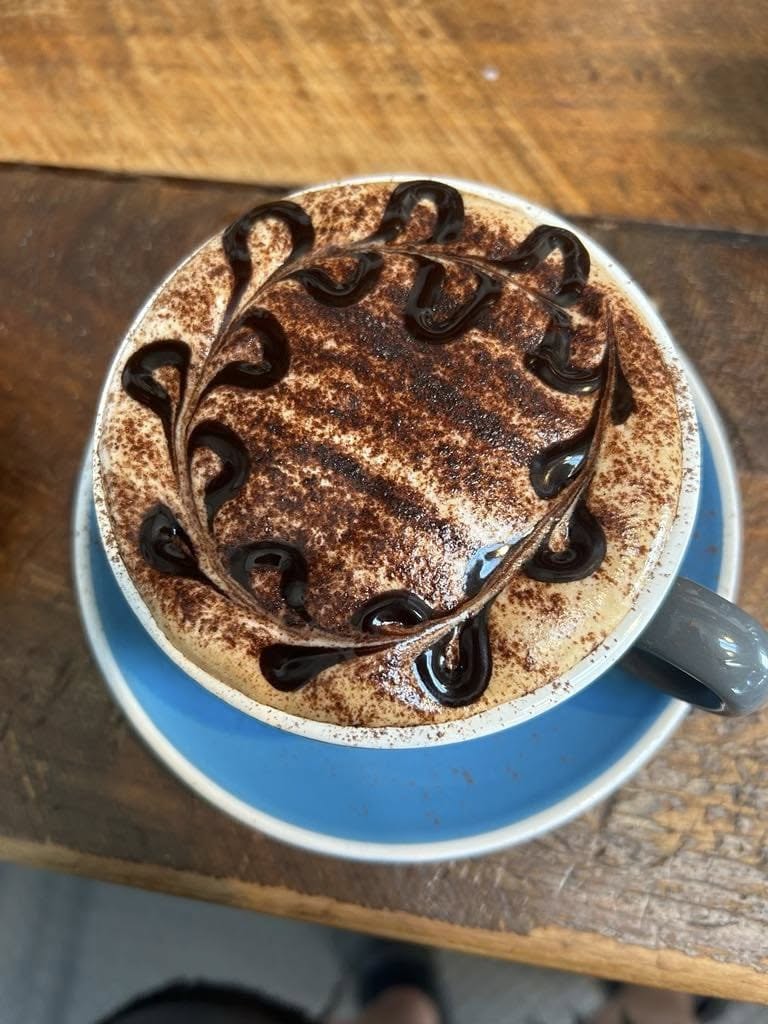 A cappuccino dusted with cocoa and finished with a chocolate swirl
