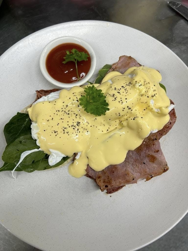 Eggs Benedict: poached eggs and bacon on spinach with hollandaise and a side of relish